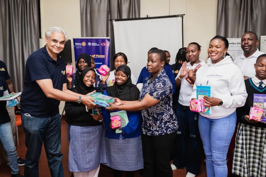 The firm’s team handing over books and supplies to students